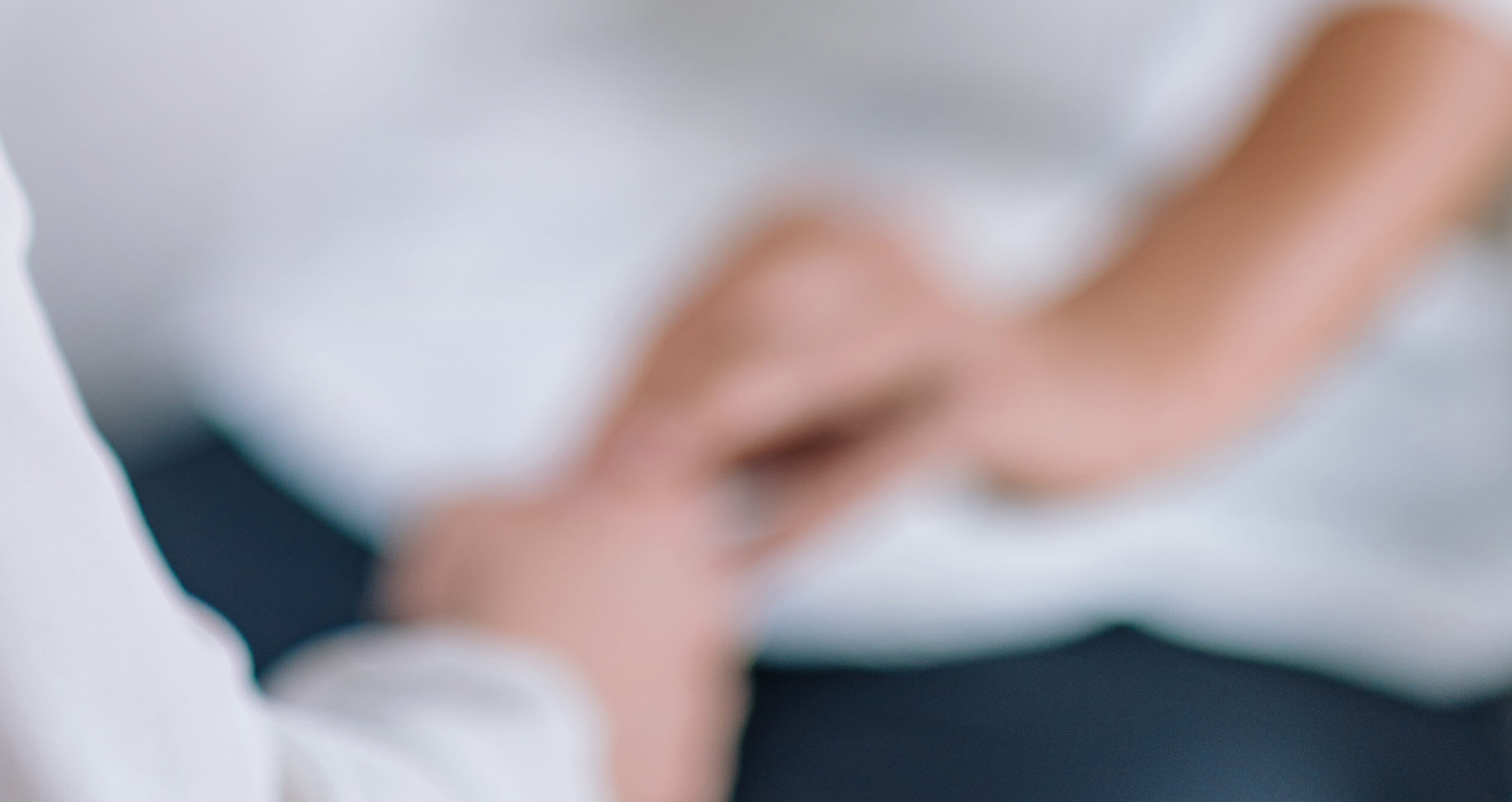 Female Theta healing therapist performing alternative therapy treatment with young woman patient. Therapist holding hands and transfer energy. Wearing white clothes.